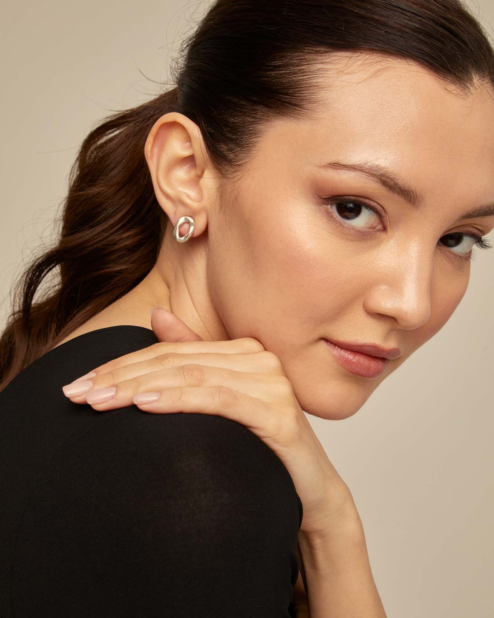Woman with dark hair and shirt wearing UNOde50 Joy of Living Oval Link Shape Stud Silver Earrings