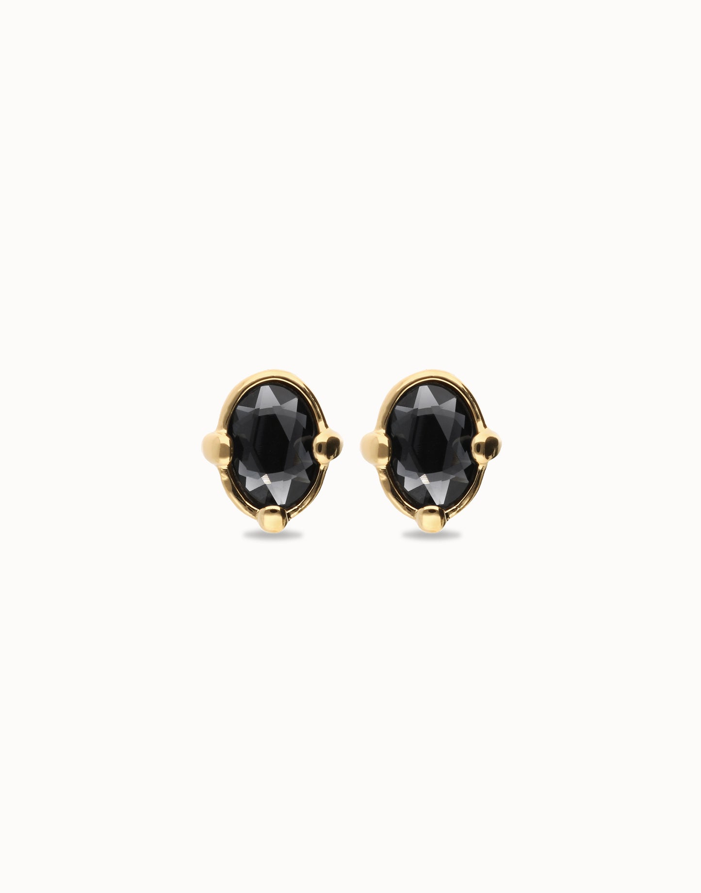 Front view of UNOde50 Ser Deslumbrante Gold Stud Earrings with Black Oval Crystal on white background