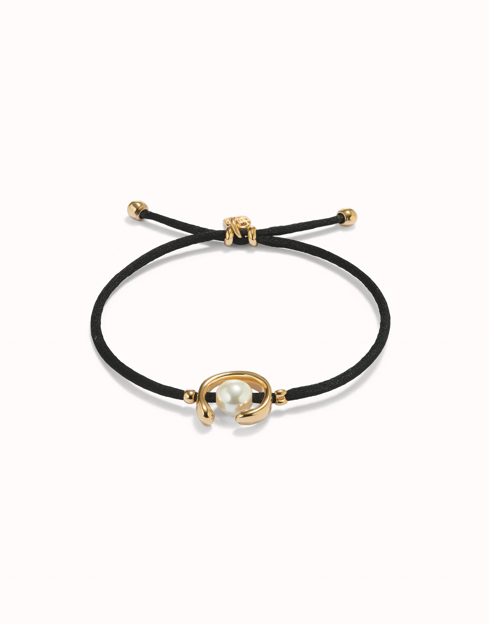 Black cord bracelet with gold clasp and pearl charm on a white background