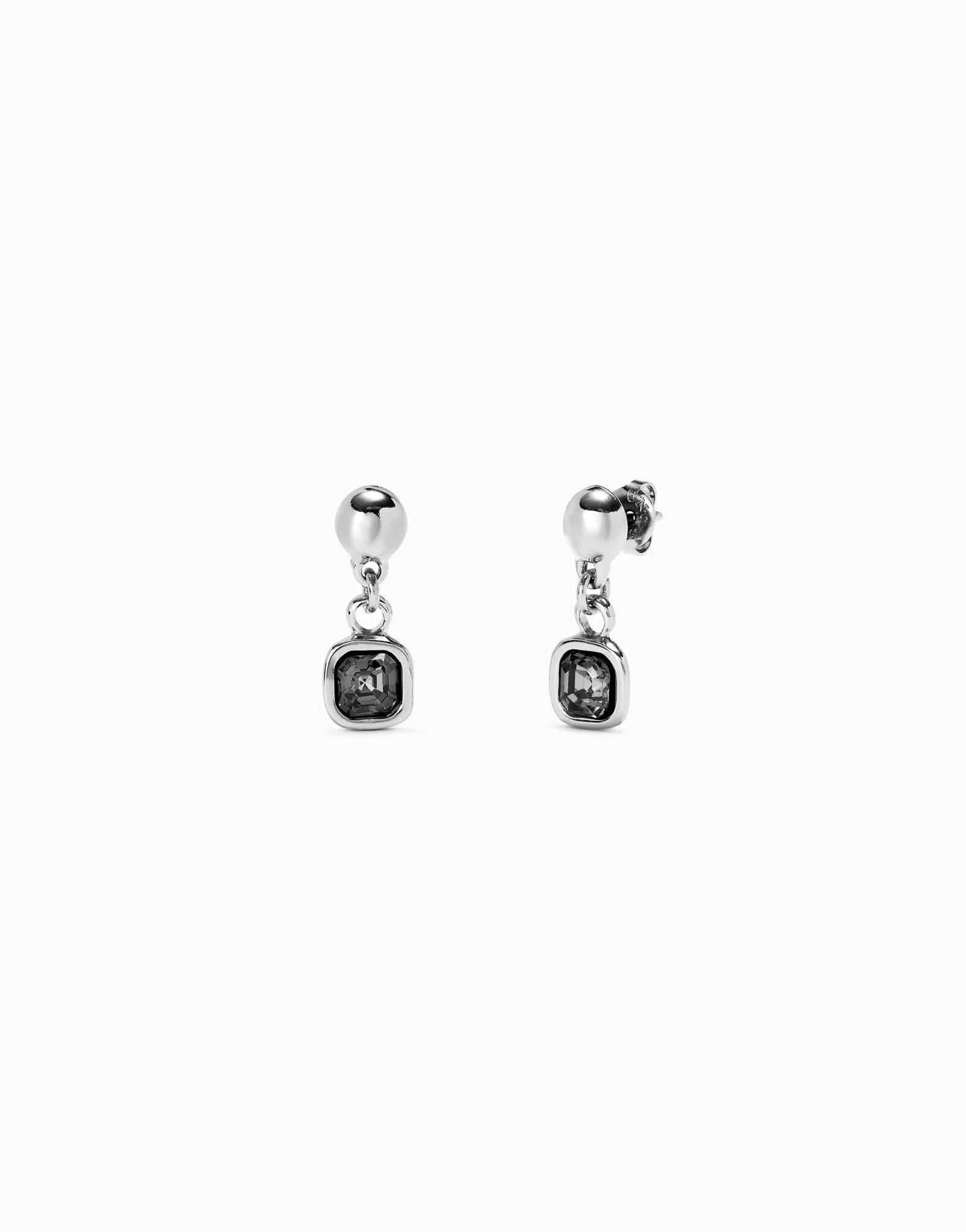 Pair of silver UNOde50 ser expresiva earrings with gemstones on a white background