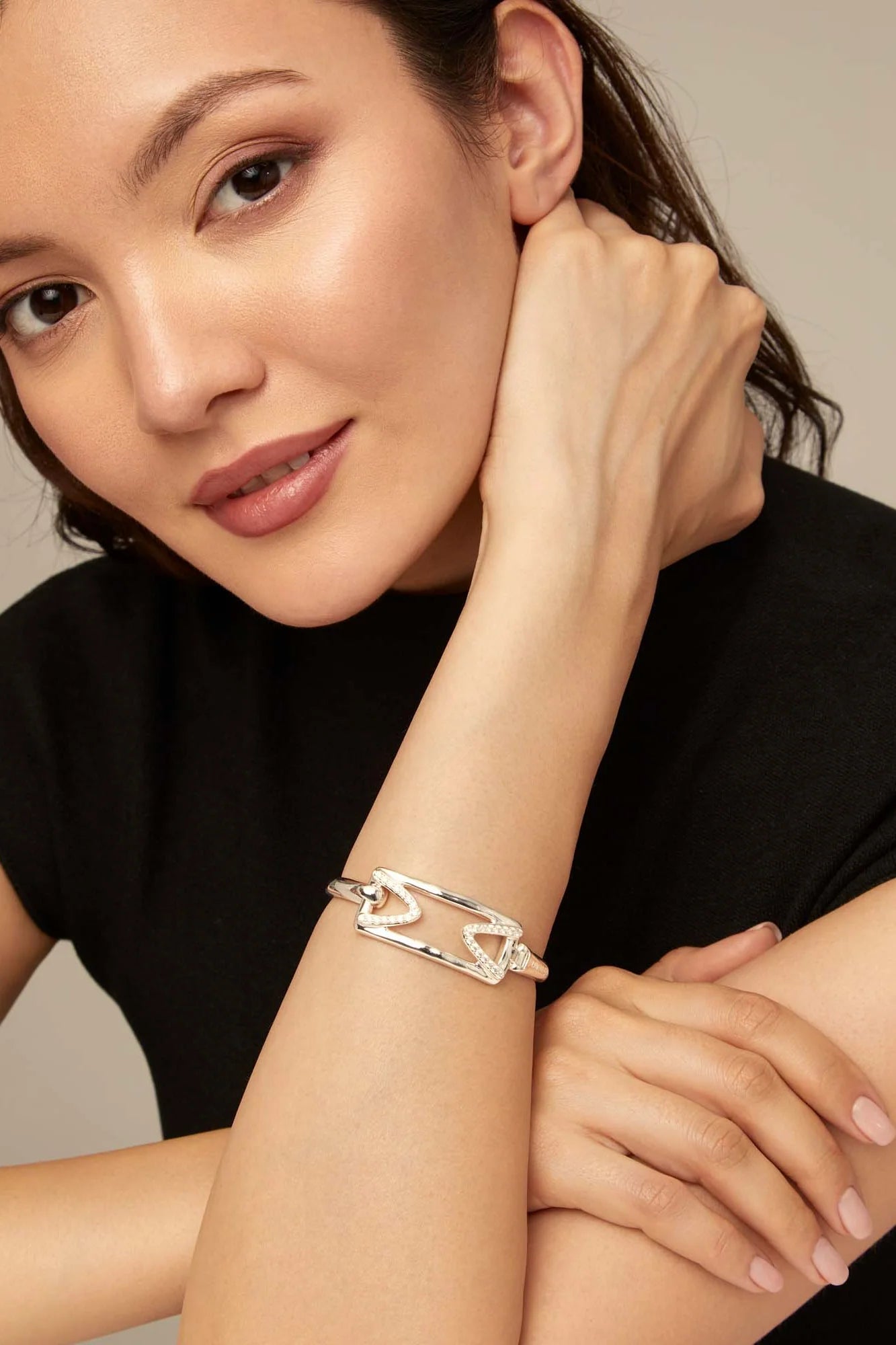 Woman wearing an UNOde50 Stand Out Silver Cuff Bracelet With Topaz Accent on her wrist with a neutral background
