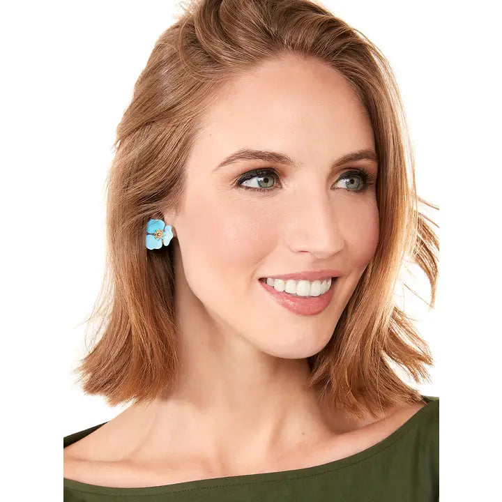 Woman wearing a pair zenzii colorul blossom earrings in blue on a white background