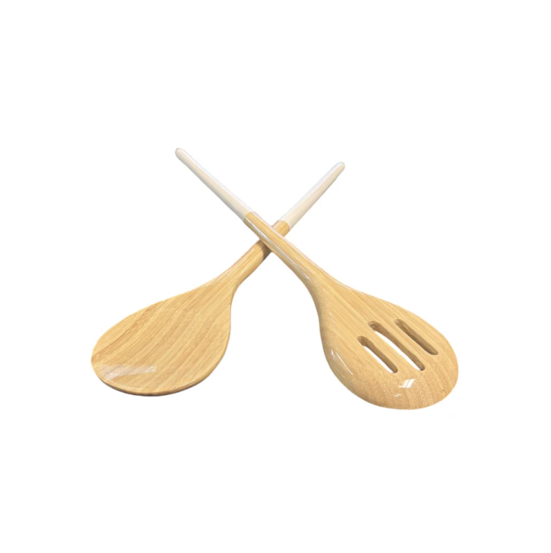 A pair of wooden salad servers, with one slotted spoon and one solid spoon, crossed over each other. the ends of the servers are white