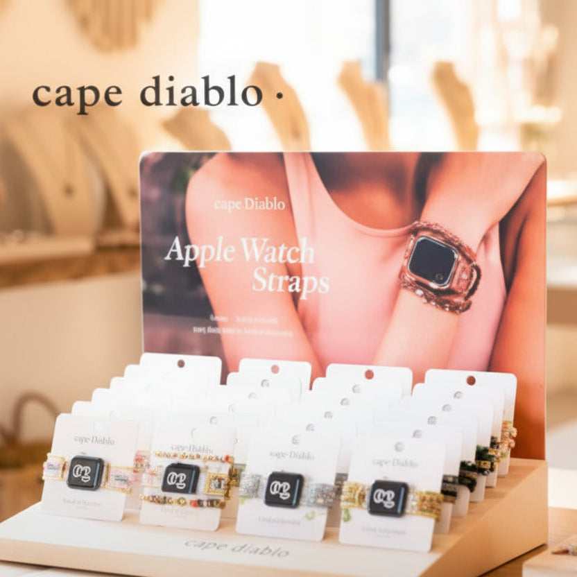 Cape Diablo apple watch band jewelry display with variousbands on a wooden table.