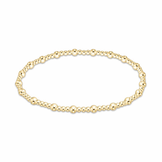 A delicate gold beaded enewton Sincerity bracelet with small, polished 3mm and 2mm spherical beads, displayed in a horizontal oval shape against a plain white background.
