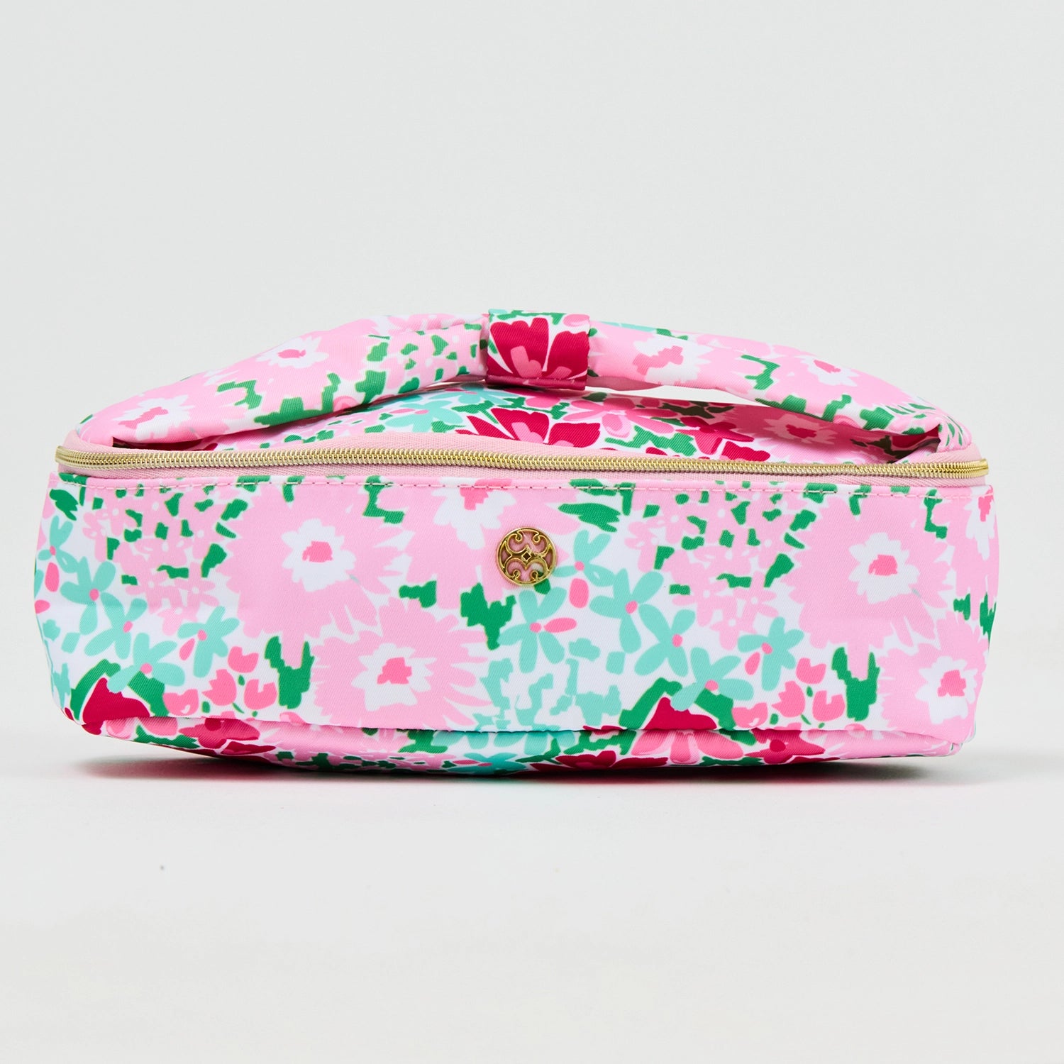 Floral patterned cosmetic bag in shades of pinks and greens with a bow handle