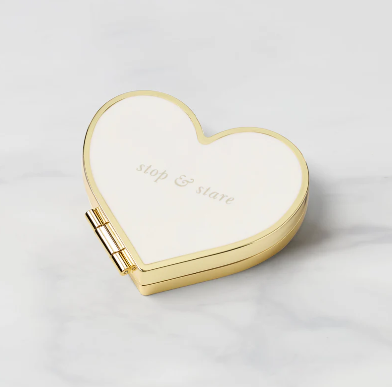 Heart-shaped cream compact mirror with gold frame and the words stop & stare