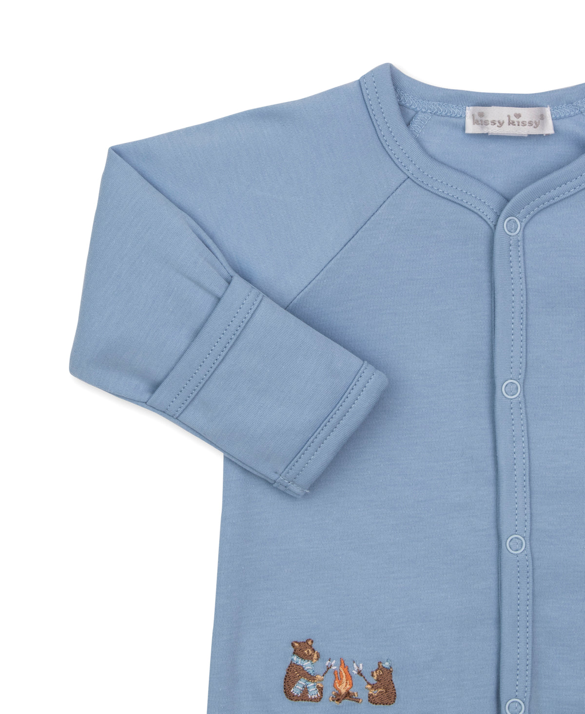 A light blue long-sleeve baby cardigan featuring a button-down front, raglan sleeves, and a small embroidered campfire bear motif near the bottom hem.