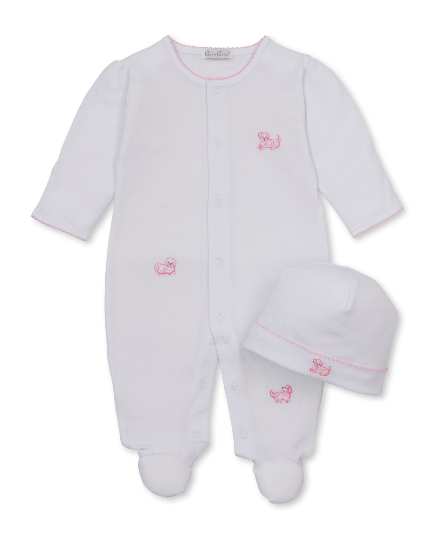 A white baby footed sleeper with long sleeves and a matching white beanie hat, both featuring small pink embroidered puppy motifs and pink trim, displayed on a clean white background.