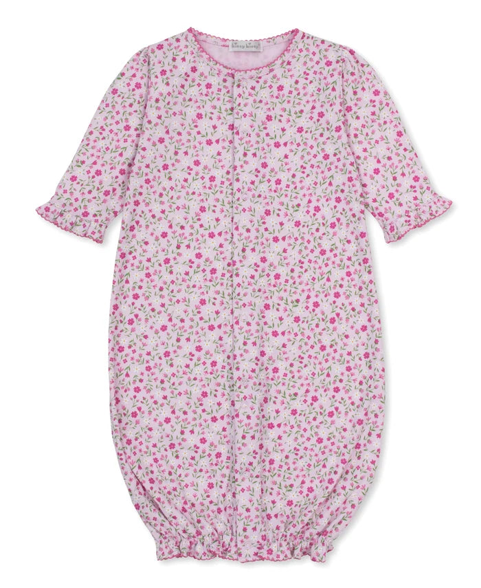 A kissy kissy pretty petals baby convertible gown with a pink and green floral print on a white background, featuring ruffled sleeves and a smocked bottom.