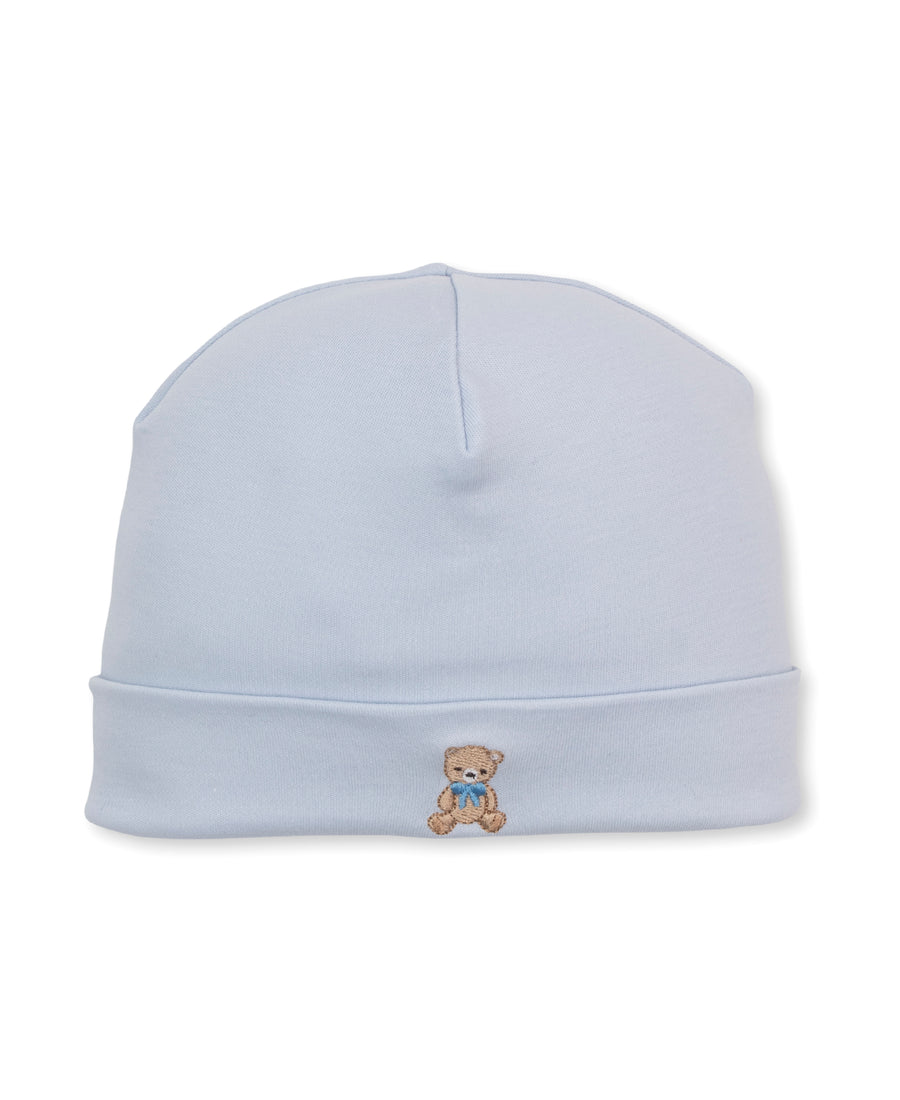 Kissy Kissy light blue teddy bear club light blue knit baby beanie hat featuring a small embroidered teddy bear with a blue bow on the front cuff, set against a plain white background.