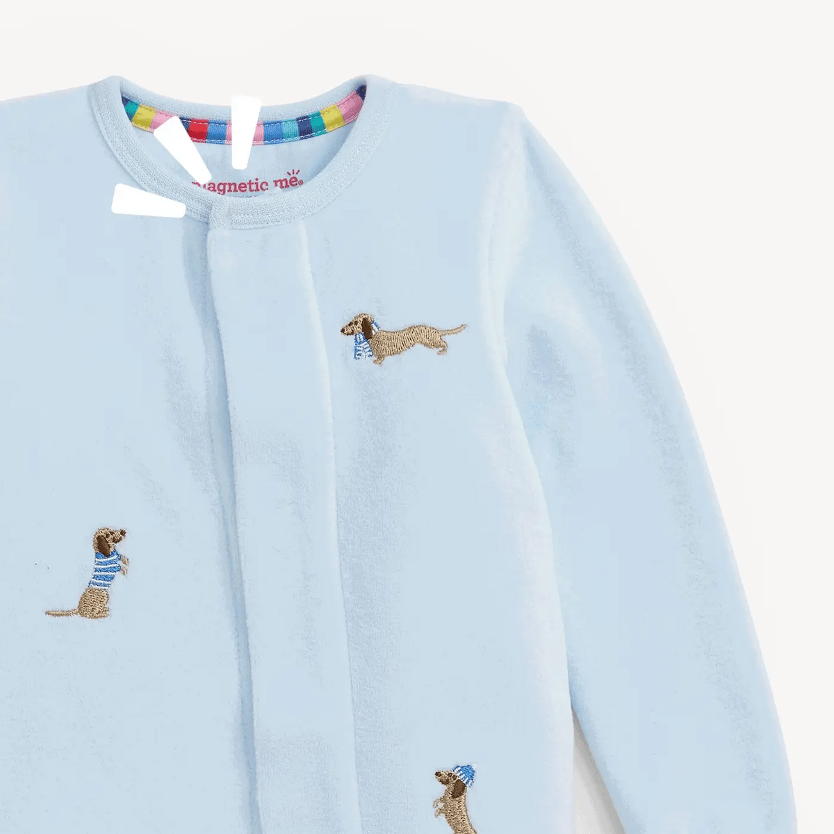 A light blue long-sleeve baby velour footie with embroidered dachshund dogs wearing striped shirts, shown on a clean white background.
