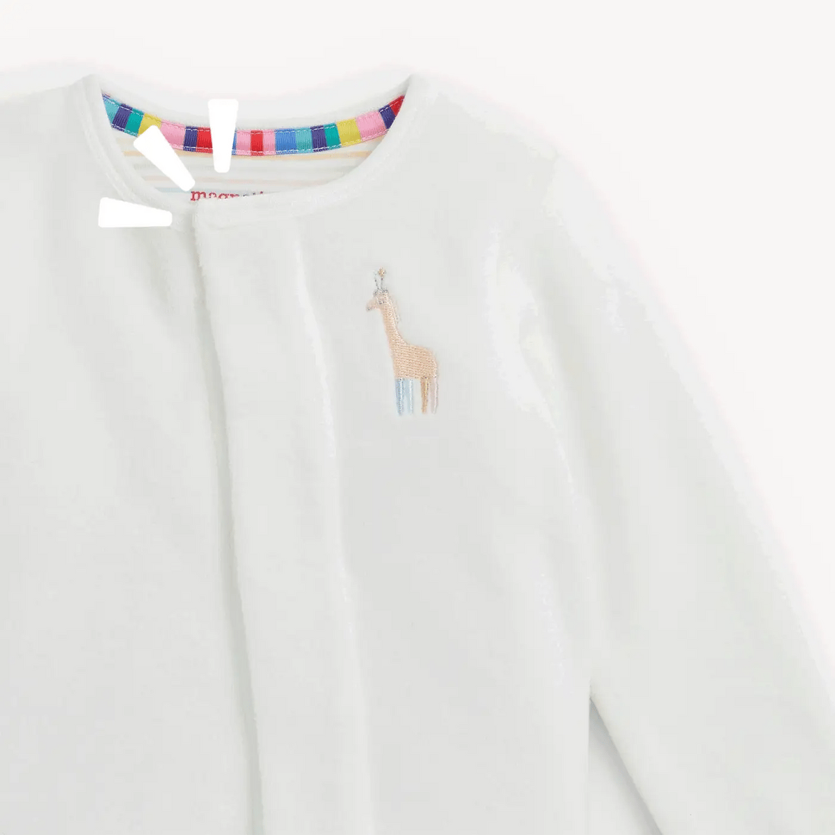 Close-up of a white long-sleeve children's footie with a small embroidered giraffe on the chest and a colorful striped inner collar.