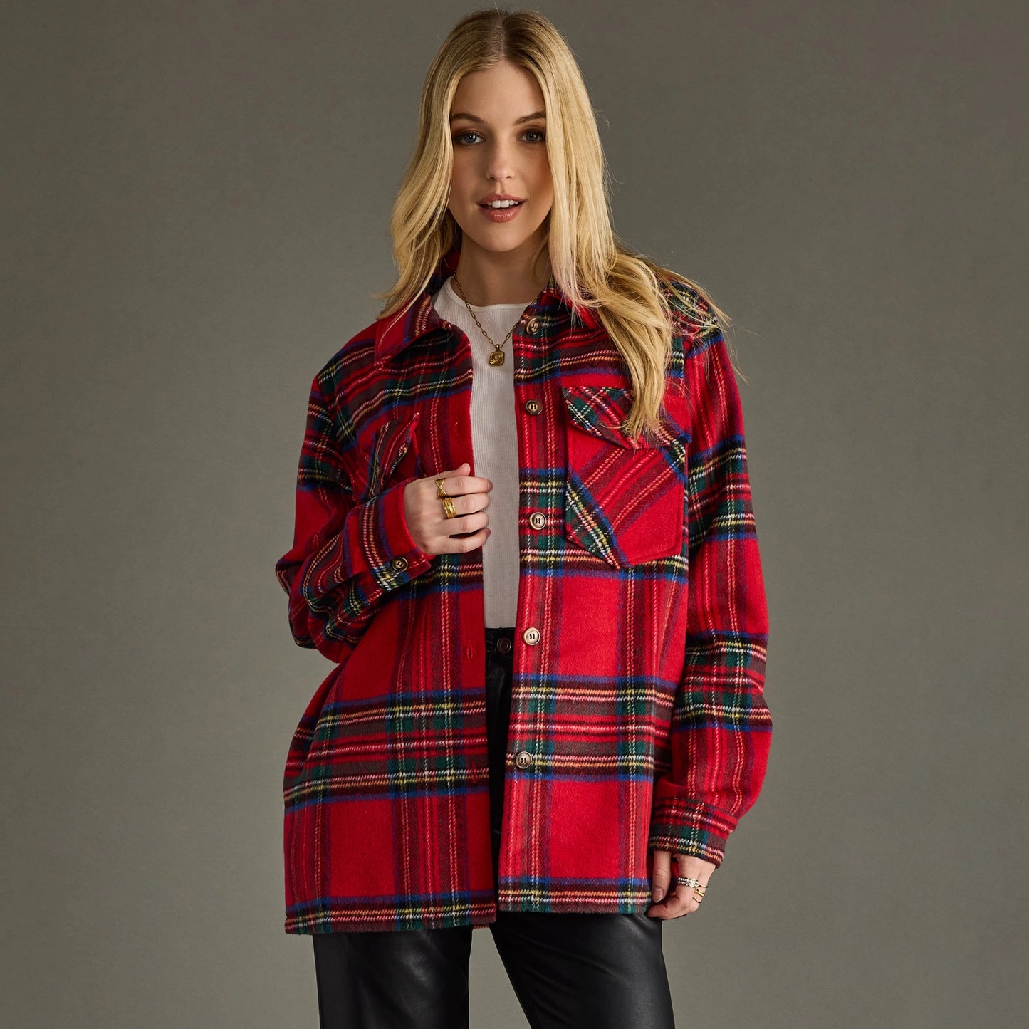 A woman modeling an oversized red plaid button-up shirt jacket over a white top and black pants.