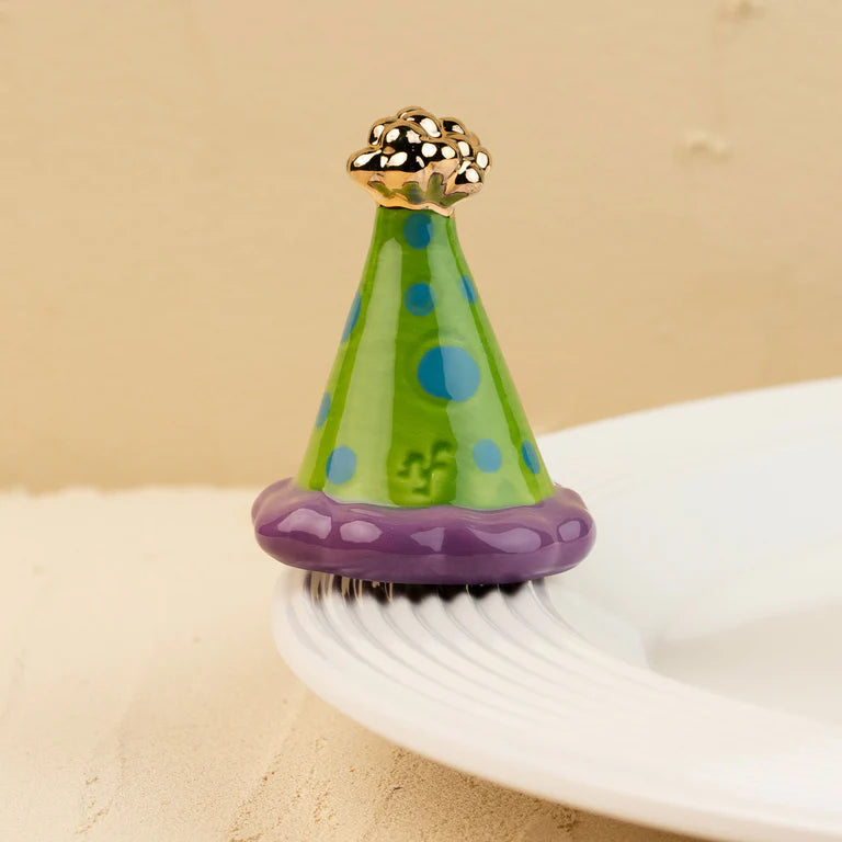 nora fleming mini party hat with a green and blue polka dot design and purple and gold accents