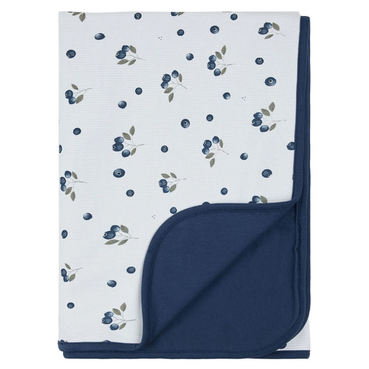 A folded baby blanket featuring a white front with a blueberry and leaf pattern, and a solid navy blue reverse side.