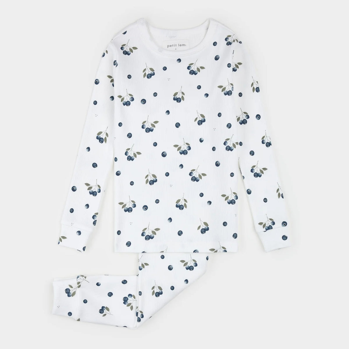 A two-piece children's pajama set by Petit Lem, featuring a long-sleeve top and matching pants in white with a repeating print of blueberries and leaves.