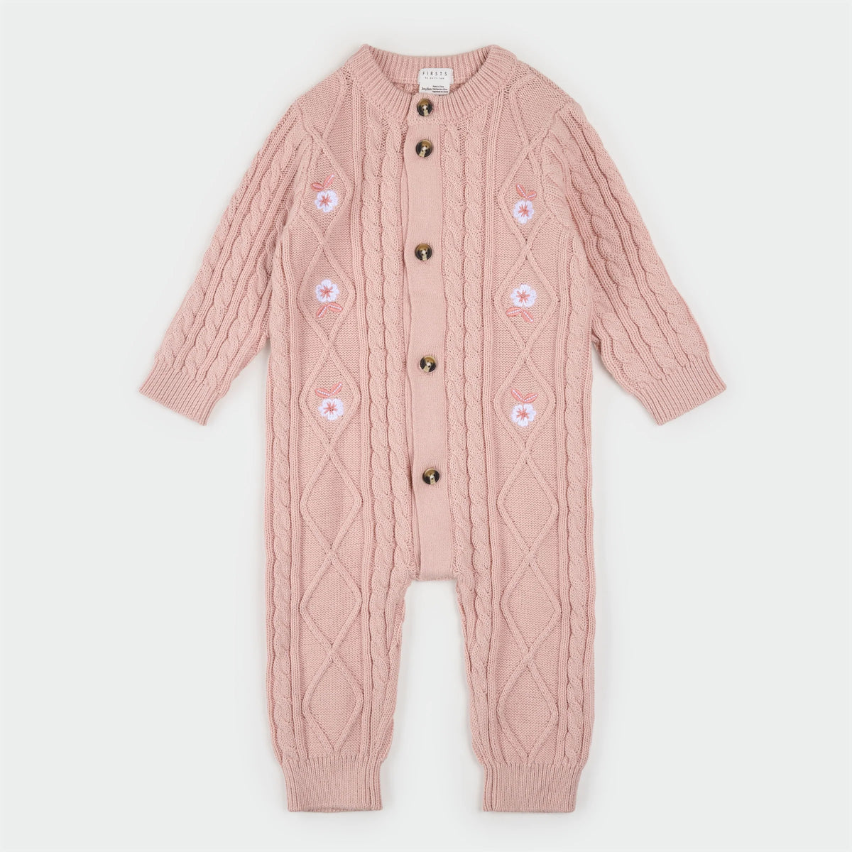 Pink sweater knit playsuit with white embroidered flowers on the sides and brown buttons