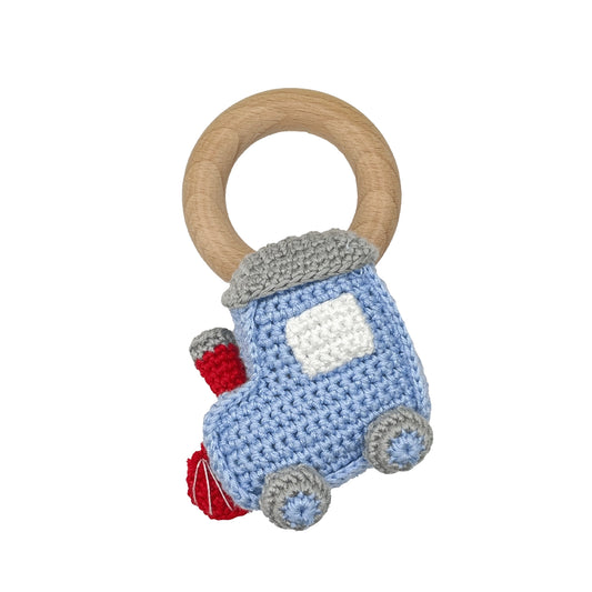 A baby teething toy and rattle featuring a light blue crocheted car with gray wheels and roof, a red bumper, and a natural wooden ring handle.