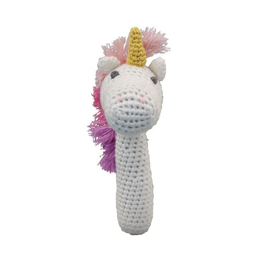 A white crocheted unicorn head rattle with a yellow horn, pink and purple fluffy mane, and small black eyes, shown on a plain white background.