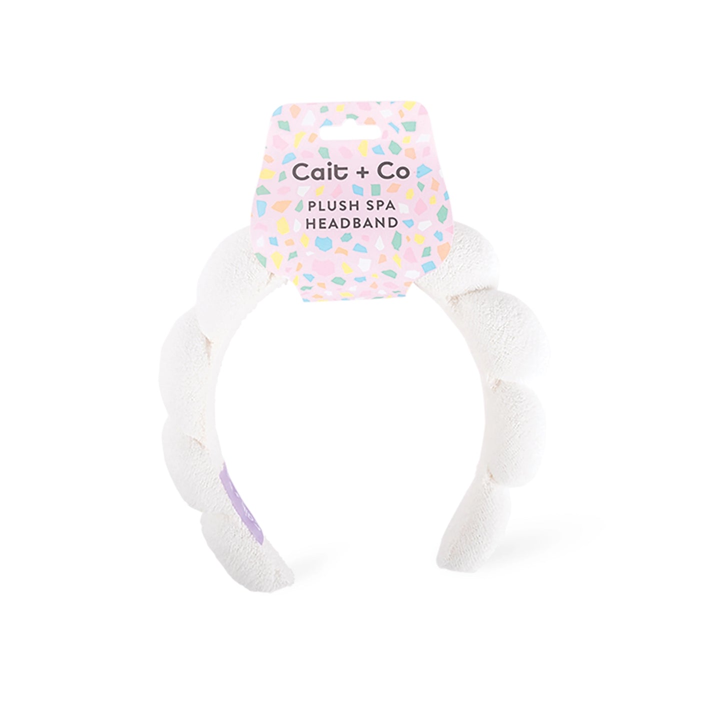 White plush spa headband with a colorful label 