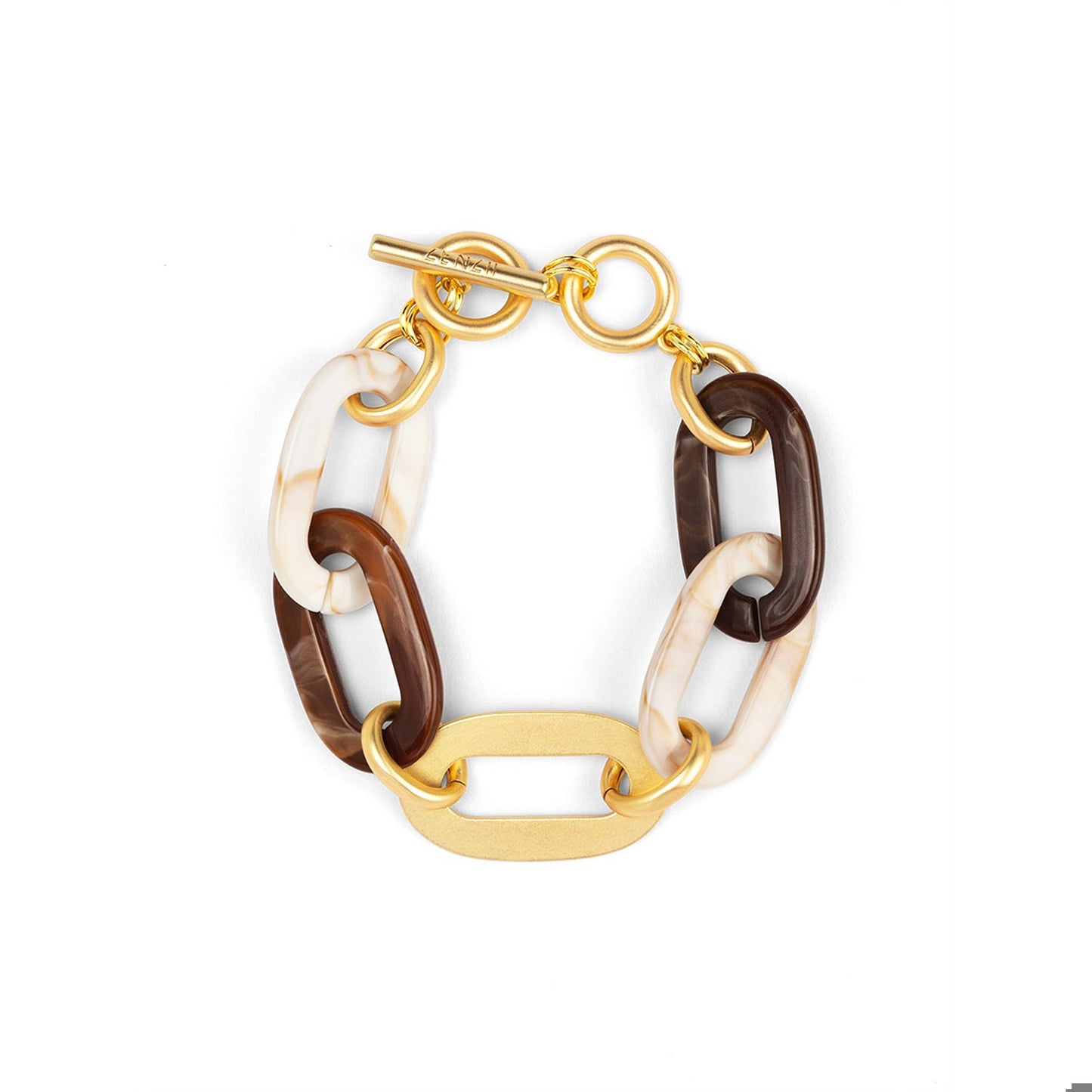 A gold-tone chain link bracelet featuring alternating links of dark brown and cream-white marbled resin, with a flat gold-tone center link and toggle clasp.
