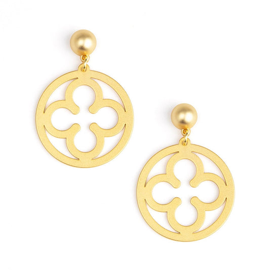 A pair of gold-tone drop earrings featuring a circular quatrefoil cutout design with a small round pearl-like stud at the top, shown on a plain white background.